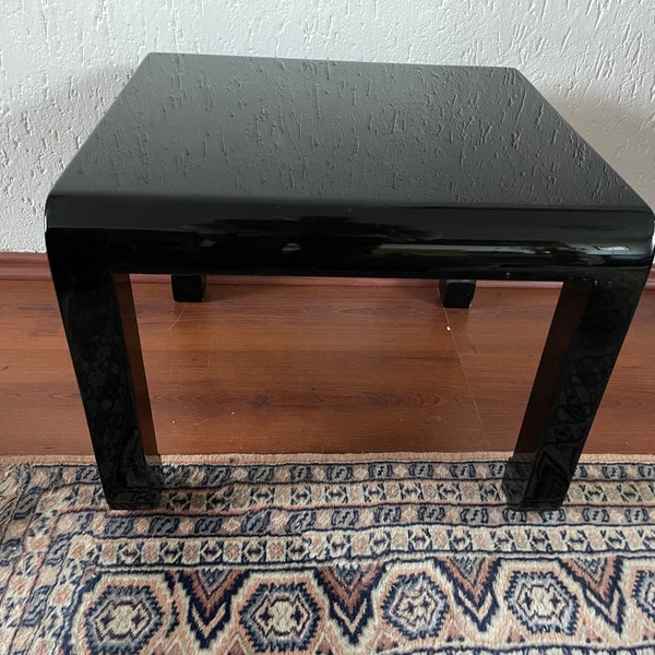 Table basse ou table d'appoint chinoise laquée noir brillant 50x49x39 cm. Un oiseau de feu est très légèrement représenté sur le dessus. En bon état vintage