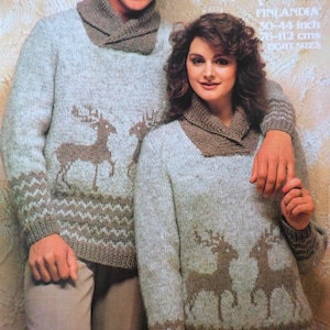 May include: Light grey knit sweaters with brown deer designs and collar detail. The sweaters have a brown zig-zag pattern at the cuffs and hem. The text "FINLANDIA" and size information are visible (76-112 cms).