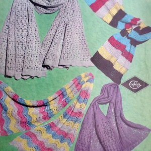 May include: An assortment of knitted scarves in various colors and patterns. The image features a light gray open-weave scarf, a striped scarf with black, blue, red, and yellow stripes, and a purple open-weave scarf. The text "COBWEB WOOL" is visible.