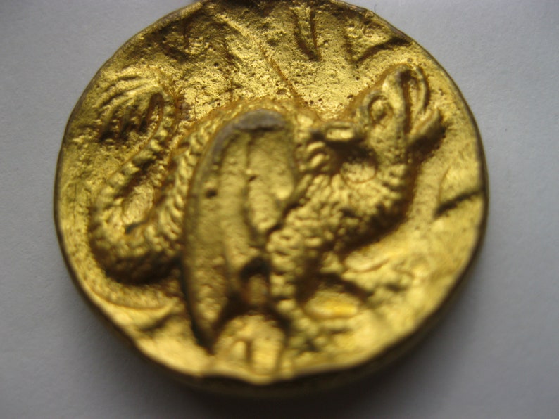 Antique brass button featuring dragon has brass loop shank and measures 1.18 dia