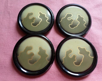 Set of 4 large flat celluloid buttons with pattern have black japanned base and measure 1.5/8" dia