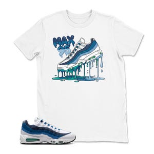 May include: White t-shirt featuring a graphic of a blue and white sneaker with dripping paint and the text "MAX 95". The shirt is paired with a matching blue and white sneaker.