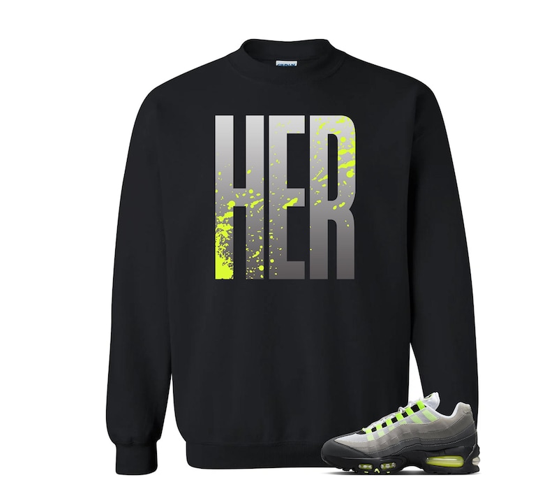 Puede incluir: Sudadera negra con la palabra "HER" en letras grandes, grises y amarillo ne&oacute;n. Un par de zapatillas grises, negras y amarillo ne&oacute;n en la parte inferior de la imagen.