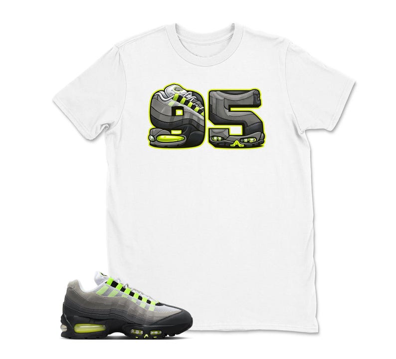 May include: White t-shirt with a graphic of the number "95" in a sneaker design, with black, gray, and neon green accents. A matching sneaker is in the foreground, featuring a black, gray, and neon green color scheme.
