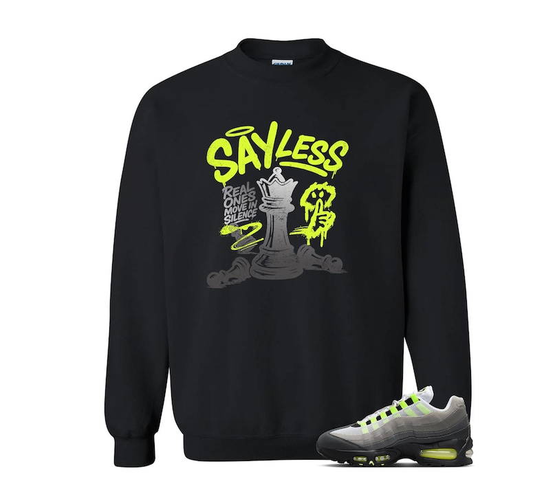 Puede incluir: Sudadera negra con un dise&ntilde;o gr&aacute;fico en verde ne&oacute;n y gris. El gr&aacute;fico incluye el texto "SAY LESS" y una pieza de ajedrez. Un par de zapatillas grises y negras con detalles en verde ne&oacute;n est&aacute;n en la esquina inferior derecha.