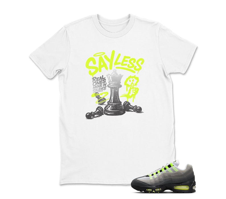 Puede incluir: Camiseta blanca con un gr&aacute;fico de ajedrez en negro y verde ne&oacute;n. El gr&aacute;fico incluye una pieza de ajedrez de reina y el texto "SAY LESS". Un par de zapatillas deportivas negras, grises y verde ne&oacute;n est&aacute;n en primer plano.