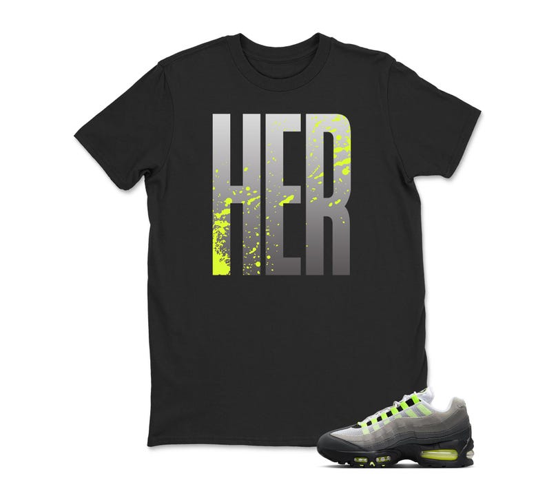 Puede incluir: Camiseta negra con la palabra "HER" en letras grandes y grises con salpicaduras de color verde ne&oacute;n. Un par de zapatillas deportivas grises, negras y verde ne&oacute;n est&aacute;n en primer plano.