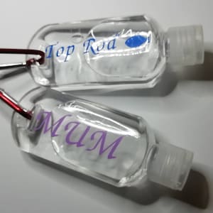 Personalised plastic bottle with carabiner clip to be filled with liquid of your choice - hand sanitiser, sunscreen etc.  Own name added.