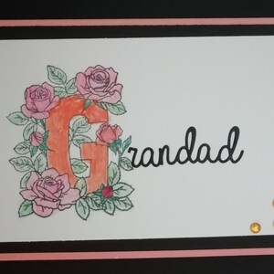 Tarjeta de 7x5 pintada a mano con el sentimiento Abuelo con la letra G iluminada decorada con rosas de color agua.