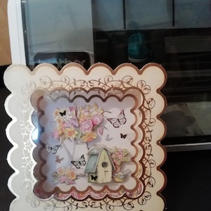 A beautiful handmade 3D card featuring flowers and birds and butterflies