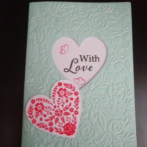 Una hermosa tarjeta hecha a mano de 7x5 con un diseño floral en relieve. Corazón escandinavo y el sentimiento con amor. Azul huevo de pato con rojo y blanco.