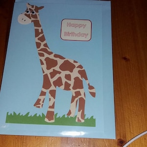Belle carte d'anniversaire faite main de girafe gaie. Avec des yeux brillants et une sensation de votre choix. Peut être personnalisé.