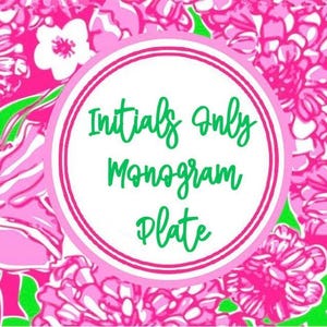May include: A pink and green floral design with a white circle in the center. The circle has a double black outline and the text "Initials Only Monogram Plate" in green.