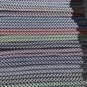 Puede incluir: Una colecci&oacute;n de cordones de zapatos en varios colores, cada uno con un patr&oacute;n de diamante blanco. Los cordones est&aacute;n dispuestos en una pila, con la parte superior de la pila siendo la adici&oacute;n m&aacute;s reciente.