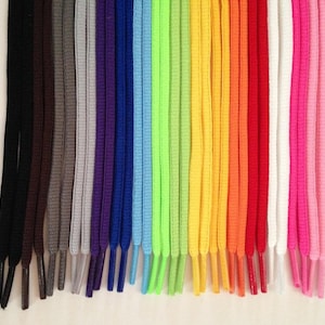 May include: A set of 20 shoelaces in various colors, including black, brown, gray, purple, blue, light blue, green, yellow, orange, red, white, and pink. The shoelaces are all the same length and width.