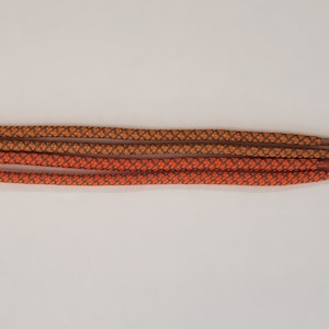 Puede incluir: Cuatro cordones para zapatos, dos naranjas y dos color marigold, con un patr&oacute;n tejido.
