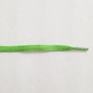May include: A bright green shoelace with a silver aglet.