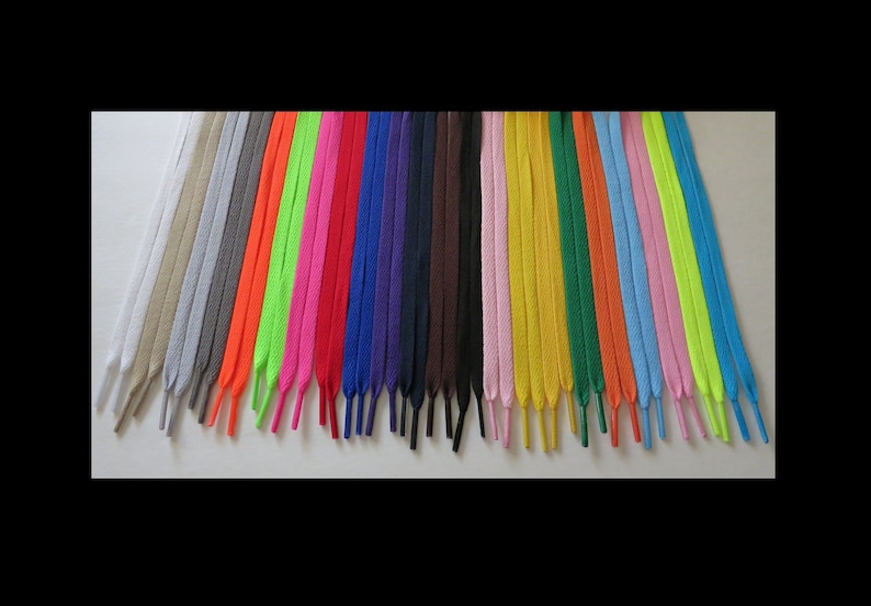 Puede incluir: Una variedad de colores de cordones para zapatos, incluyendo blanco, beige, gris, negro, rojo, azul, verde, amarillo, naranja, rosa y verde ne&oacute;n.