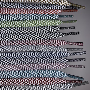 Puede incluir: Un juego de 12 cordones de diferentes colores con un patr&oacute;n de rombos blancos. Los cordones est&aacute;n dispuestos en una fila, con las puntas de los cordones apuntando hacia la derecha.