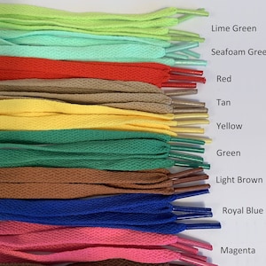 Puede incluir: Una colecci&oacute;n de cordones de zapatos en varios colores, incluyendo verde lima, verde agua, rojo, marr&oacute;n claro, amarillo, verde, marr&oacute;n claro, azul real y magenta.