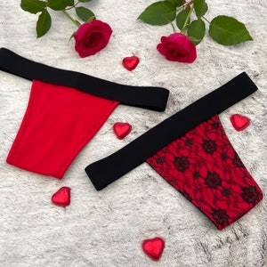 May include: Two pairs of red lingerie with black trim. One pair is solid red and the other has black lace detailing.