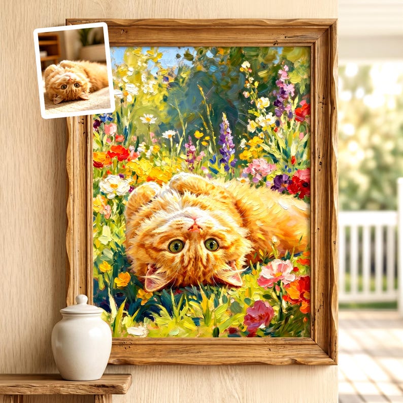 May include: A framed oil painting of a fluffy orange tabby cat lying on its back in a vibrant field of colorful wildflowers. The cat has bright green eyes and is looking upward. A small inset photo of the same cat is visible in the top left corner.
