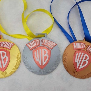 May include: Three MultiVersus medals with red, gold, and bronze finishes. Each medal features the Warner Bros. logo and the words "MultiVersus" around the edge.