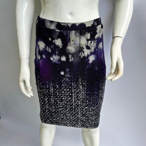 May include: A purple and white patterned skirt with a fitted silhouette. The skirt has a gradient design with a darker purple at the bottom and a lighter purple at the top. The skirt is made of a soft, stretchy fabric.