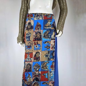 Puede incluir: Una falda larga azul y roja con un diseño de patchwork que presenta imágenes de personas y animales. La falda tiene un forro azul.