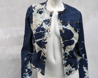 May include: A blue denim jacket with a white bleach splatter design. The jacket has a button-up front and long sleeves.
