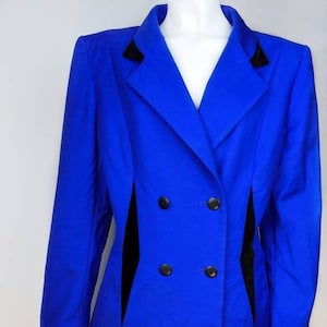 May include: A royal blue double-breasted blazer and skirt suit with black velvet trim. The suit has a classic tailored fit.