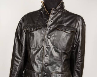 May include: A black leather jacket with a button-up front and multiple pockets. The jacket has a stand-up collar and a slightly fitted silhouette.