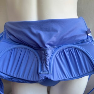 Pu&ograve; includere: Top costume da bagno blu pervinca con un design strutturato. Il top presenta un dettaglio in tessuto arricciato e un laccio al collo. Il costume da bagno &egrave; esposto su un manichino.