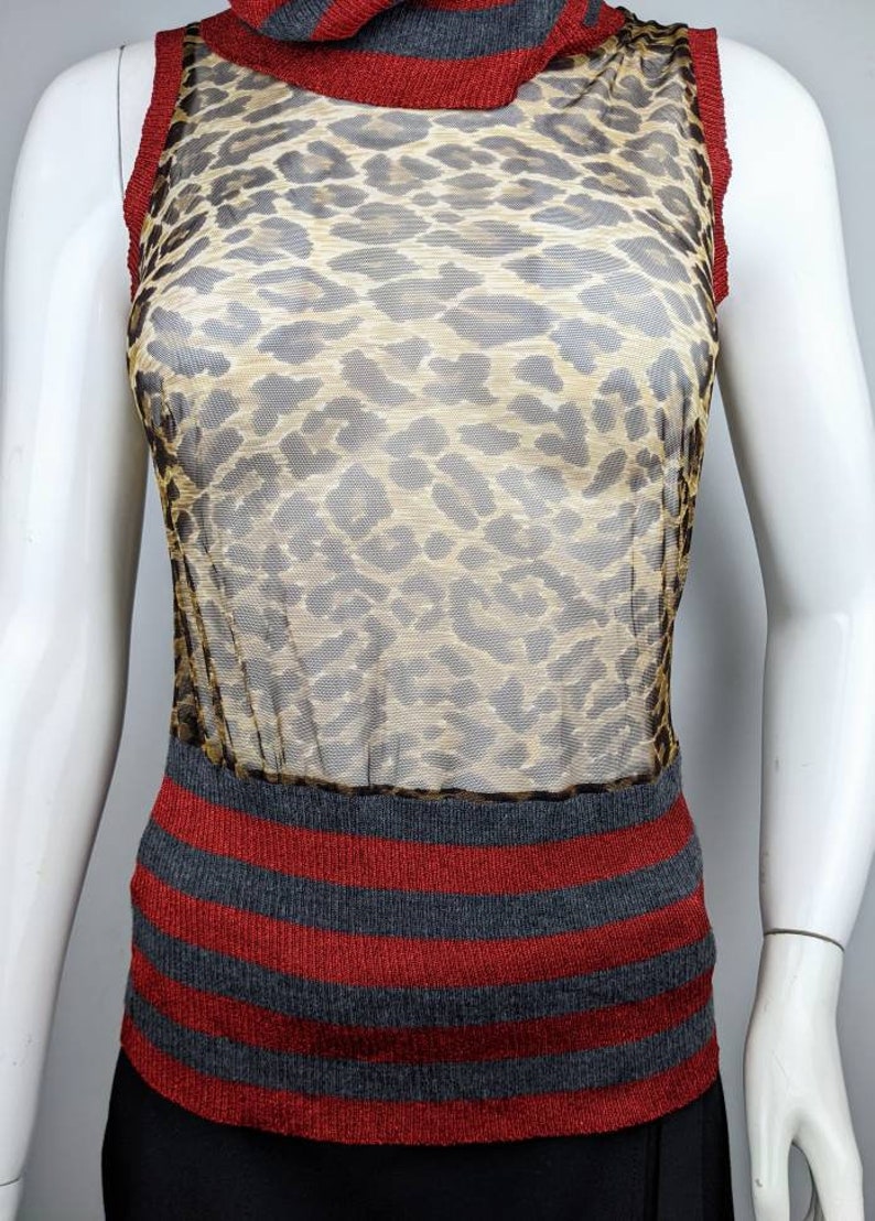 May include: A sleeveless, sheer, leopard print top with a red and gray striped knit bottom.