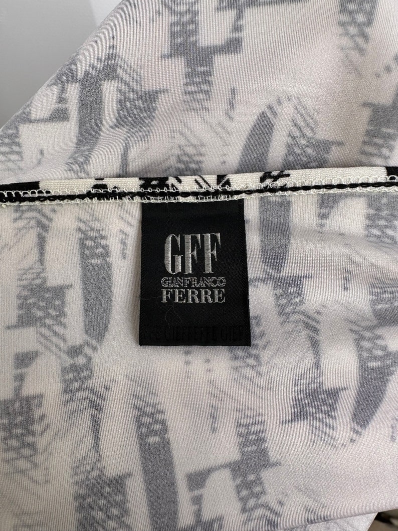May include: A black and white label with the text "GFF GIANFRANCO FERRE" on a white background with a black and white pattern.