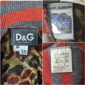 May include: A black and red striped shirt with a leopard print mesh panel. The shirt has a D&G label with the text "Made in Italy" and "Dolce & Gabbana". The shirt also has a label with the text "Ittierre" and "Made in Italy". The shirt is size XS.