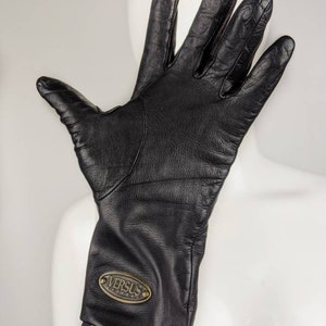 May include: Black leather gloves with a gold oval logo that says "VERSUS VERSACE".