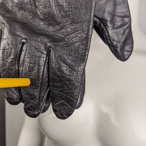 May include: Black leather gloves with a textured surface.