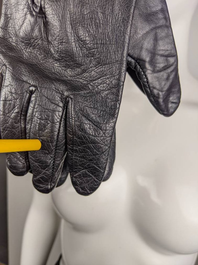 May include: Black leather gloves with a textured surface.