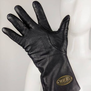 May include: Black leather gloves with a gold oval logo that says "VERSUS" on the cuff.