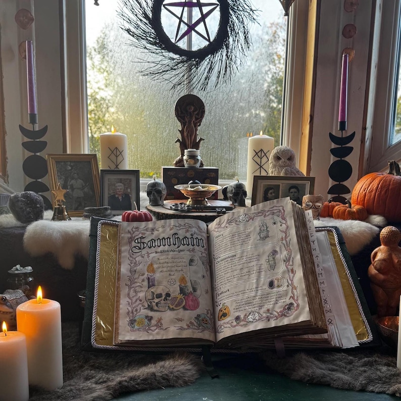May include: An open book with the word "Samhain" on the cover, surrounded by candles, pumpkins, and decorative items. A wreath with a pentagram hangs in the background. The scene evokes a mystical or spiritual theme.
