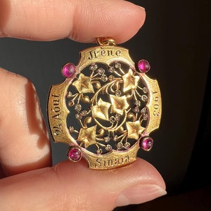 May include: A gold pendant with a floral design and the text "Irene 24 Aout 1903 Sinaia". The pendant is decorated with small pink gemstones.