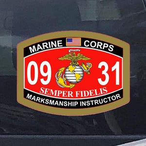 May include: A red, gold, and black Marine Corps sticker with the text "MARINE CORPS" and "09 31" in white. The sticker also features the American flag, an eagle, globe, and anchor emblem, and the words "SEMPER FIDELIS" and "MARKSMANSHIP INSTRUCTOR."