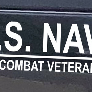 May include: White vinyl decal with the text "U.S. NAVY" and "COMBAT VETERAN" with three stars and stripes on either side of the text.