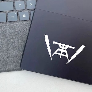 May include: White vinyl sticker with a silhouette of a telescope on a tripod with lightning bolts on either side. The sticker is on a black laptop.