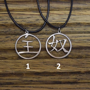 Peut inclure: Deux colliers en argent avec des caractères chinois sur des pendentifs circulaires. Le collier de gauche porte le caractère "王" et le collier de droite porte le caractère "奴".