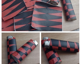 May include: Four lighters with red and black checkered designs. The lighters are on a wooden surface and a patterned paper background.