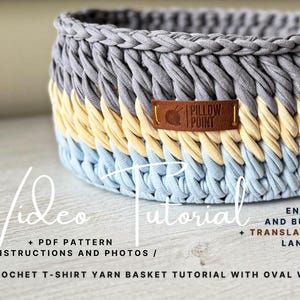 Może przedstawiać: Ręcznie robiony kosz na szydełku w odcieniach szarości, żółci i błękitu. Kosz ma tkaną fakturę i brązową skórzaną metkę z napisem "PILLOW POINT". Widoczny jest również tekst "Video Tutorial".