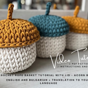 Peut inclure: Trois paniers en crochet faits à la main en forme de glands. Les chapeaux sont jaune moutarde, sarcelle et or, et les corps sont blanc cassé. Les paniers sont faits avec un fil épais semblable à une corde. L'image comprend le texte "Video Tutorial".