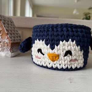 Crochet basket tutorial, penguin crochet basket pattern, easy crochet video class, beginner crochet course, t-shirt yarn basket, crochet home decor, handmade Christmas gift idea, kids room storage basket, holiday crochet pattern, crochet for beginners, crochet pattern PDF, step-by-step crochet tutorial, crochet wooden base basket, DIY crochet decor, multilingual crochet course, crochet basket design 2025, crochet craft idea, crochet digital download.